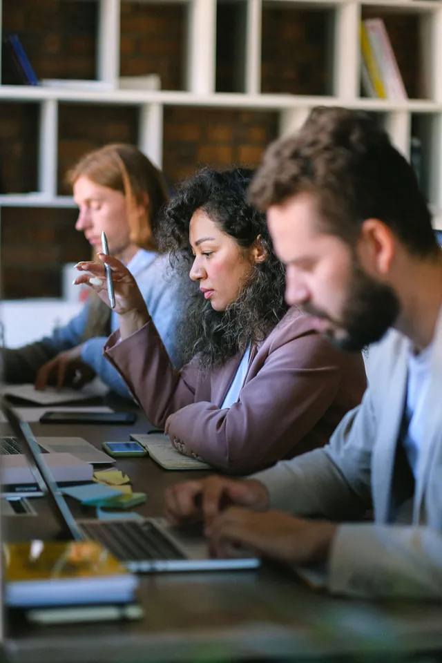 Konzentrierte Kollegen arbeiten nebeneinander an Laptops